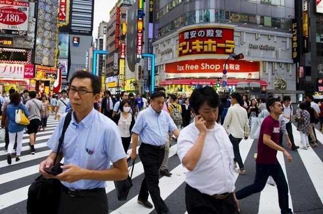 people cross a busy junction outside the nightlife district in shinjuku in tokyo photo reuters