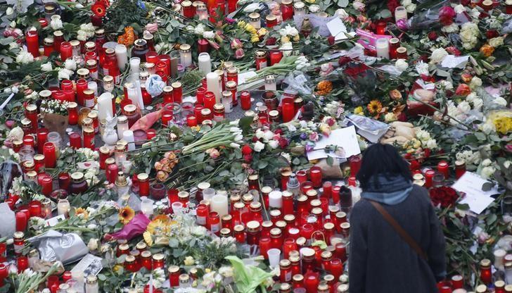 a mourner pays tribute to the victims of the dec 20 truck attack on a christmas market in the german capital of berlin photo reuters