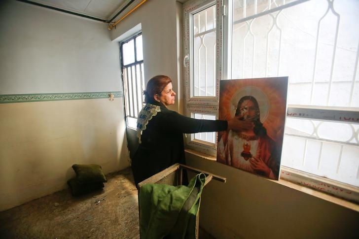 a christian woman inspects a home in the town of bartella east of mosul iraq photo reuters