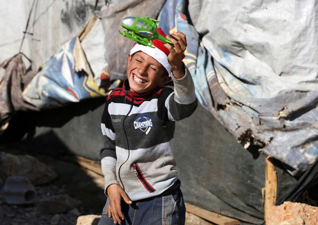 a syrian refugee child plays with his christmas gift from sawa a non governmental organisation in bar elias in the bekaa valley photo reuters