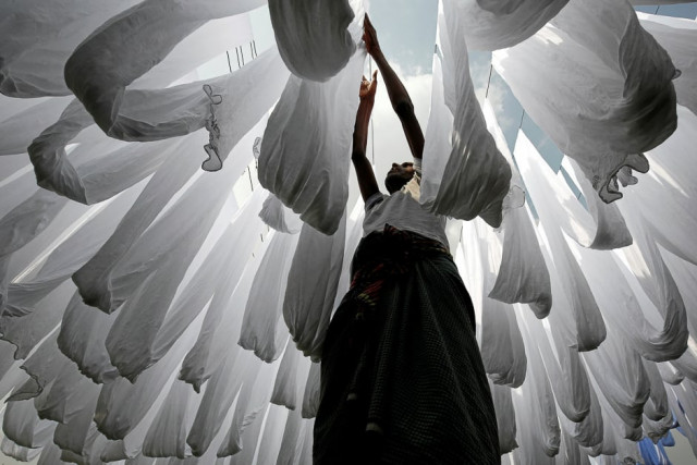 a dye factory worker suns fabric after washing them in narayanganj near dhaka bangladesh photo reuters