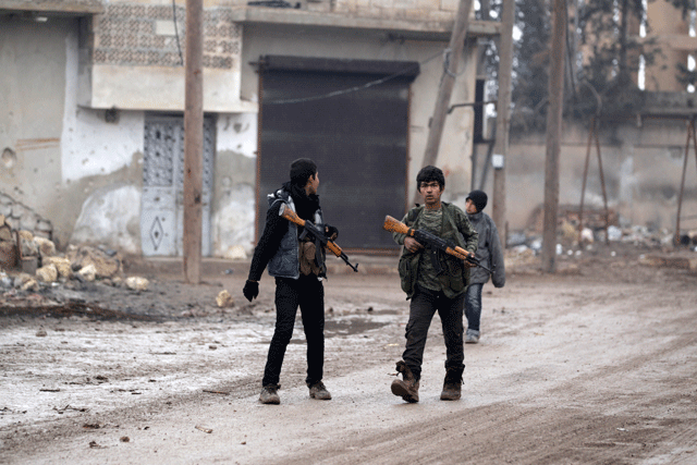 youth carry weapons along a road in al rai town northern aleppo countryside syria december 25 2016 photo reuters