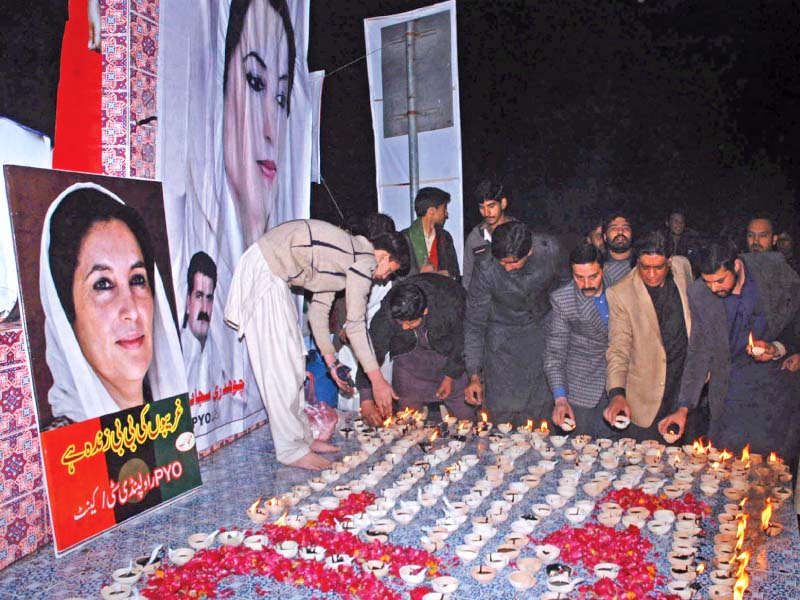 ppp workers burn lamps at the memorial of benazir bhutto photo zafar aslam express