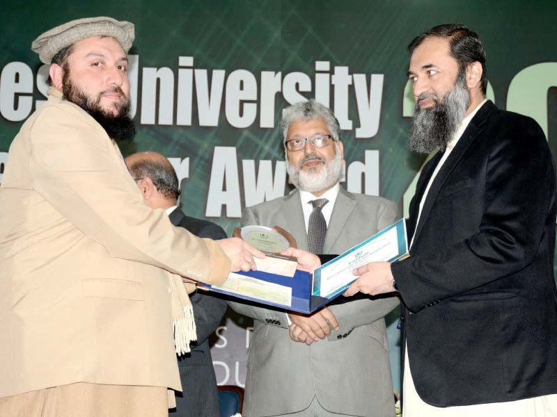 state minister for education balighur rehman hands a certificate to a varsity teacher as hec chairman prof dr mukhtar ahmed looks on photo express