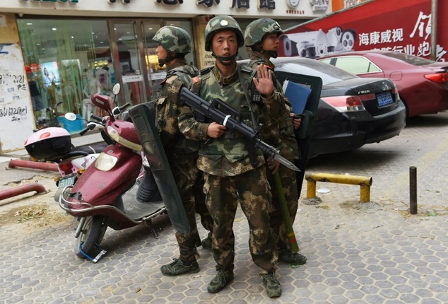 chinese paramilitary police stand guard outside a shopping mall in the western xinjiang region photo afp