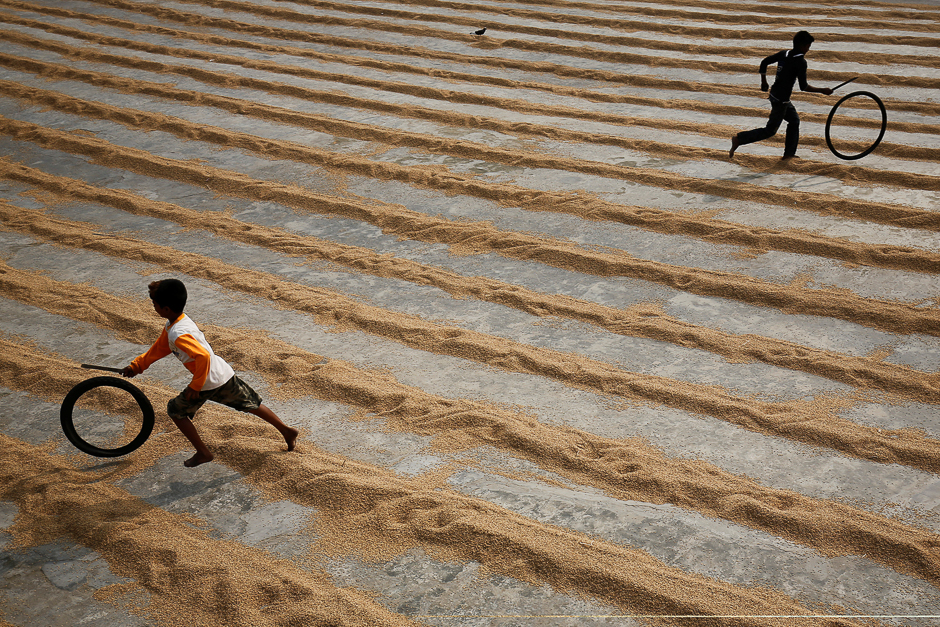 children play with bicycle tires at a rice processing mill in muktarpur on the outskirt of dhaka bangladesh photo reuters