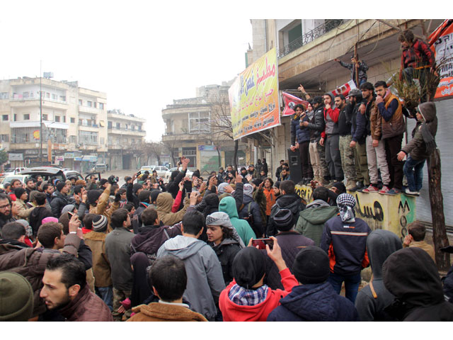 dozens of syrians take part in a small gathering calling for the fall of the regime on december 30 2016 in the northwestern city of idlib photo afp