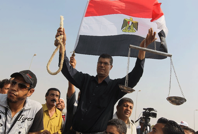 file photo shows an egyptian protester holding up a noose and a scale in front of a national flag during a protest outside the courtroom in in cairo on september 5 2011 photo afp