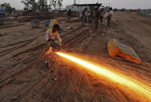 a labourer cuts an iron rod at the construction site of a flyover on the outskirts of the western indian city of ahmedabad photo reuters a labourer cuts an iron rod at the construction site of a flyover on the outskirts of the western indian city of ahmedabad photo reuters