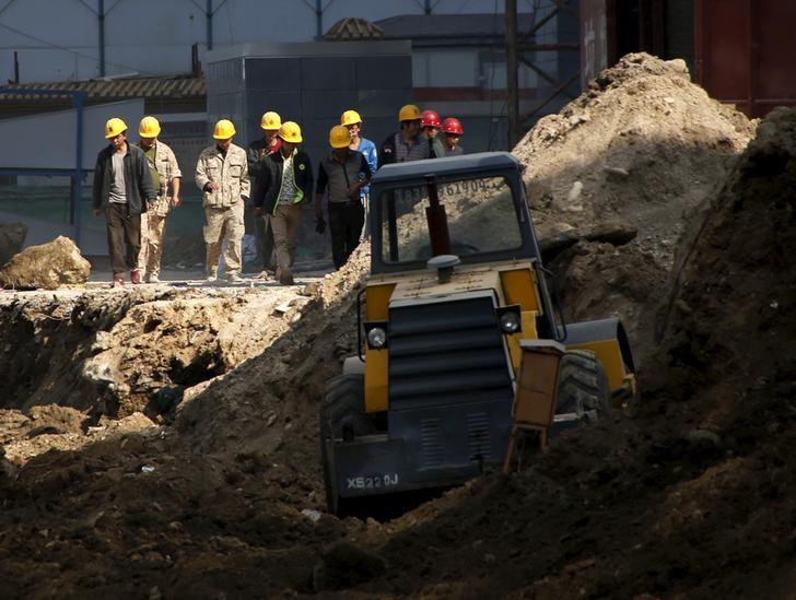 workers walk past a road construction site in beijing china october 15 2015 reuters kim kyung hoon