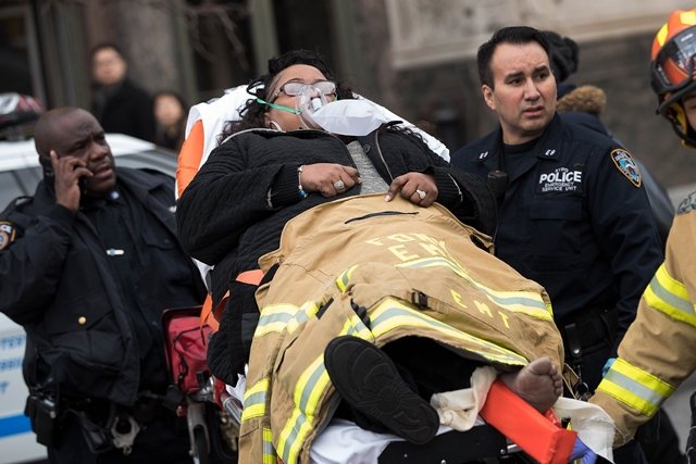 members of the new york city police department and new york city fire department carry an injured person away from atlantic terminal january 4 2017 in the brooklyn borough of new york city photo afp