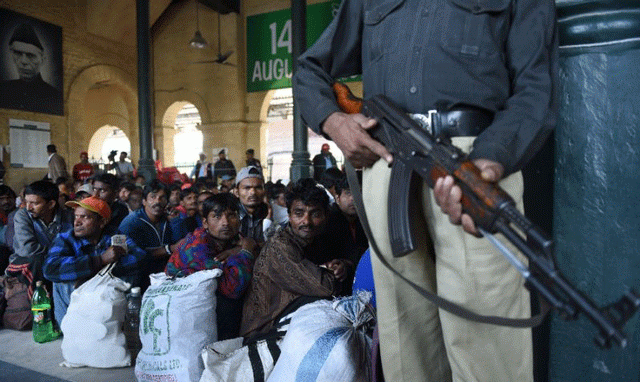 a policeman stands guard as indian fishermen await to board a train after their release at karachi railway station on december 25 2016 photo afp a policeman stands guard as indian fishermen await to board a train after their release at karachi railway station on december 25 2016 photo afp