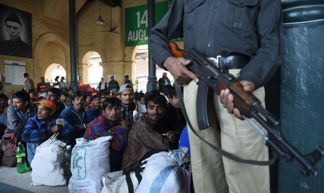 a policeman stands guard as indian fishermen await to board a train after their release at karachi railway station on december 25 2016 photo afp