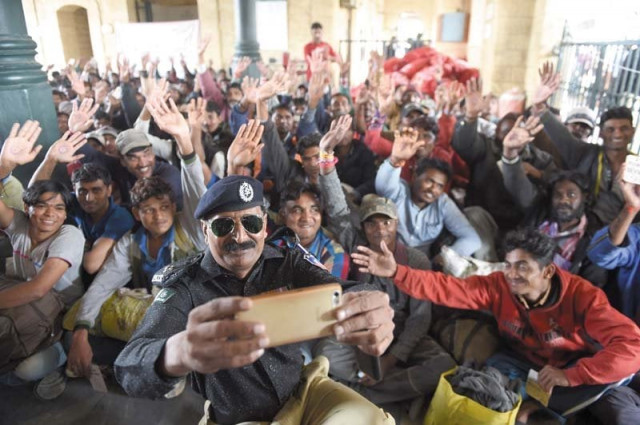 a policeman takes a selfie with indian fishermen at the karachi railway station photo afp a policeman takes a selfie with indian fishermen at the karachi railway station photo afp