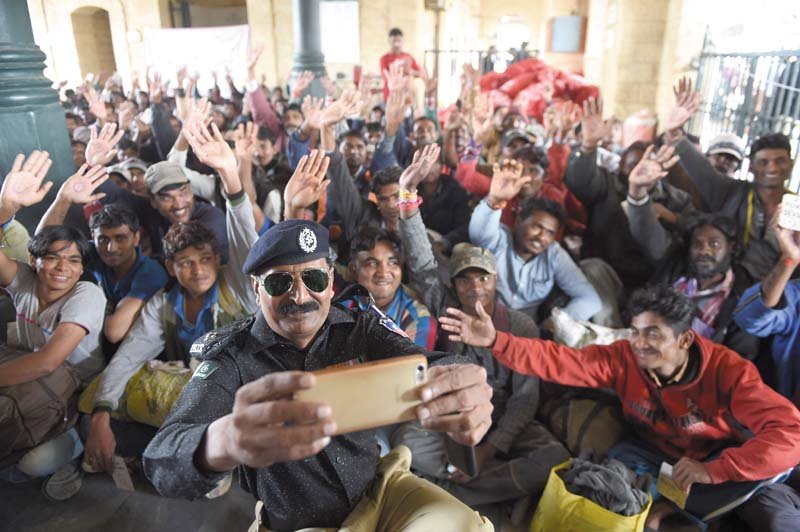 a policeman takes a selfie with indian fishermen at the karachi railway station photo afp