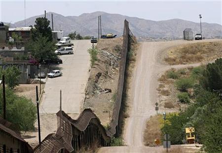 a us border patrol agent upper right waits in his jeep at his post near the wall that separates nogales sonora mexico left of wall from nogales arizona on the us and mexican border photo reuters