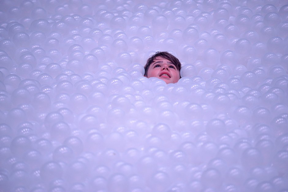 a child plays in an art installation called the beach as they quot float quot on polyethylene balls as part of the annual sydney festival photo afp