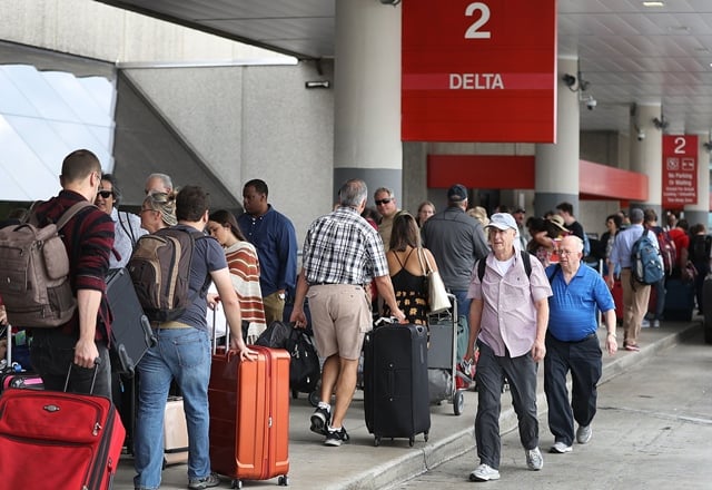 people stand in line as they wait for their flights at terminal 2 where yesterday a shooter killed five people and wounded six others in the baggage area before he was taken into custody at the fort lauderdale hollywood international airport on january 7 2017 in fort lauderdale florida photo afp