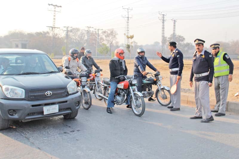 a traffic policeman explains lane rules to motorcyclists photo express