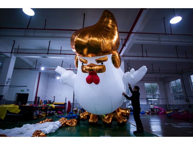 a golden mane and tiny wings that mimic his hand gestures    the resemblance of inflatable chickens produced for the chinese new year to us president elect is unmistakable photo afp