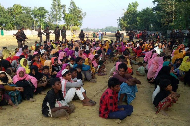 rohingya muslims from myanmar who tried to cross the naf river into bangladesh to escape sectarian violence are kept under watch by bangladeshi security officials in teknaf photo afp