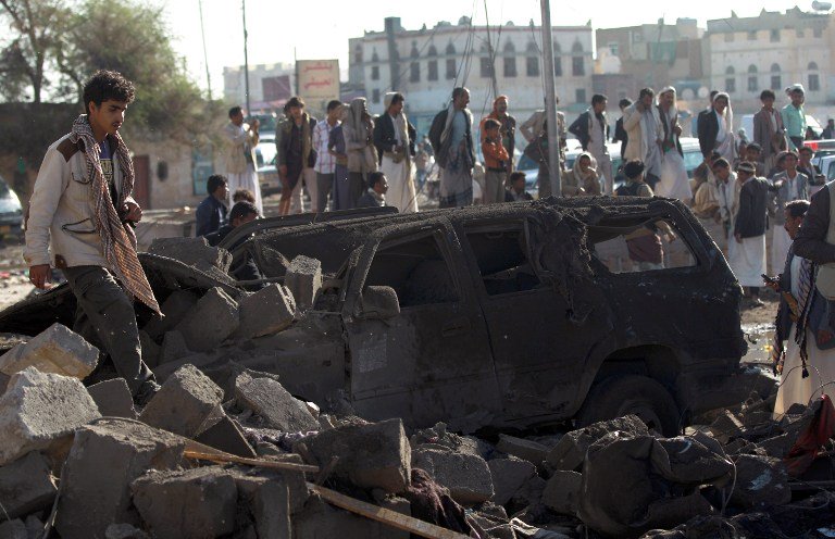 yemenis stand at the site of a saudi air strike against huthi rebels photo afp