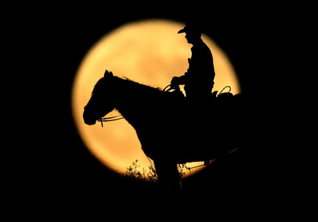 a full moon rises behind us border patrol agent josh gehrich as he sits atop a hill while on patrol near jacumba california us photo reuters