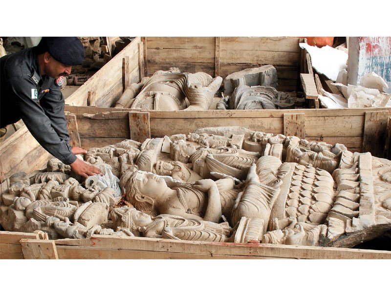 a policeman looks at a sculpture found from warehouse photo athar khan express