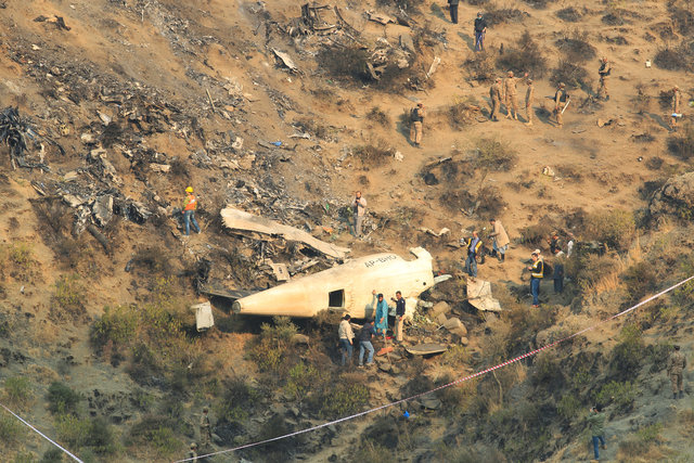 rescue workers survey the site of a plane crashed a day earlier near the village of saddha batolni near abbotabad pakistan december 8 2016 photo reuters