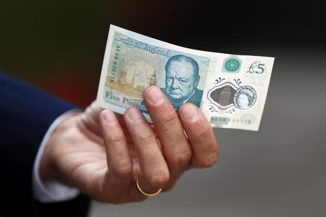 bank of england governor mark carney poses with a new polymer five pound note at whitecross street market in london britain september 13 2016 reuters stefan wermuth file photo