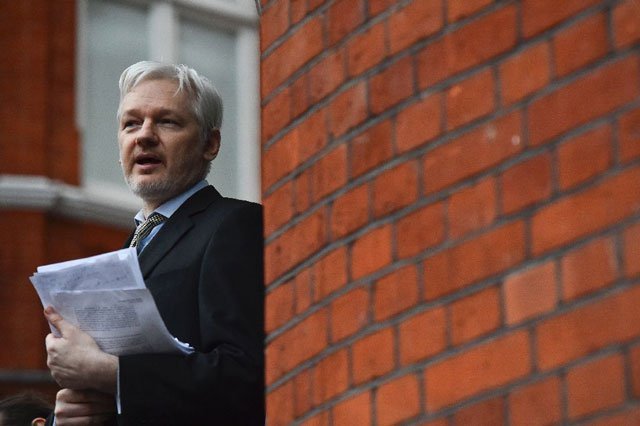 wikileaks founder julian assange addressing the media and holding a printed report of the judgement of the un 039 s working group on arbitrary detention on his case from the balcony of the ecuadorian embassy in central london on february 5 2016 photo afp