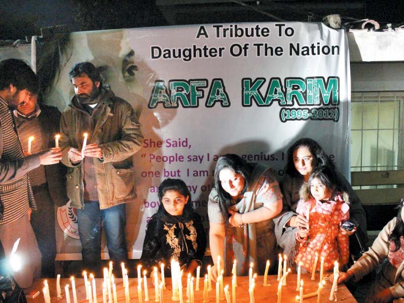 people light candles in memory of arfa karim at the press club photo express