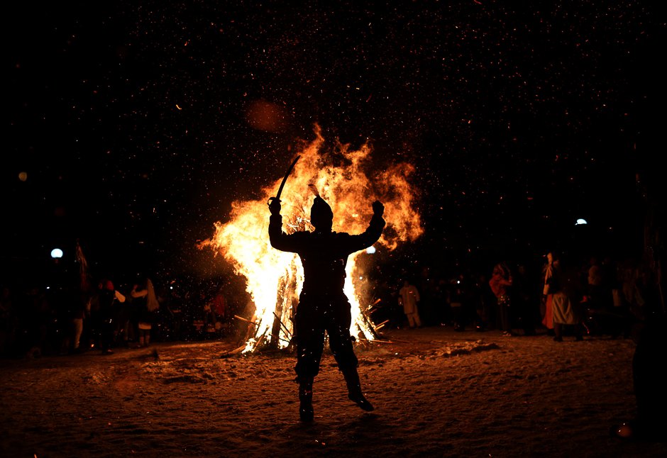 a man dressed in a costume made of animal fur called quot kuker quot dances around a bonfire during a festival in the town of batanovtsi bulgaria photo reuters