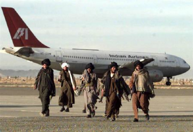 armed taliban fighters walk past the hijacked indian airlines plane at kandahar airport photo reuters armed taliban fighters walk past the hijacked indian airlines plane at kandahar airport photo reuters