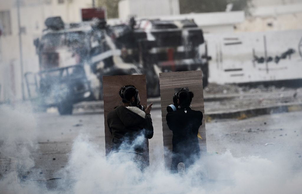 bahraini protesters are seen taking cover during a confrontation with police after a demonstration on the outskirts of the capital manama photo afp