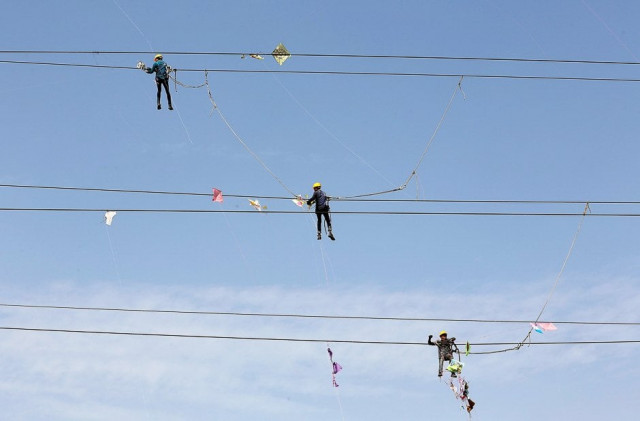 workers of torrent power limited remove kites tangled up in electric power cables after the end of the kite flying season in ahmedabad india photo reuters