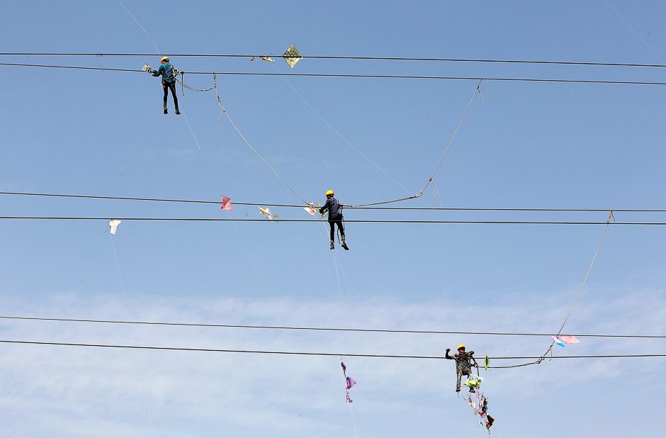 workers of torrent power limited remove kites tangled up in electric power cables after the end of the kite flying season in ahmedabad india photo reuters