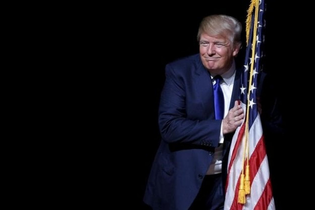 republican presidential candidate donald trump hugs a us flag as he takes the stage for a campaign town hall meeting in derry new hampshire august 19 2015 photo reuters republican presidential candidate donald trump hugs a us flag as he takes the stage for a campaign town hall meeting in derry new hampshire august 19 2015 photo reuters