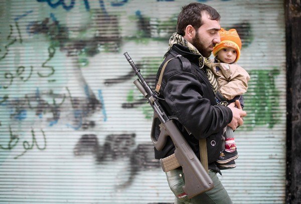 a rebel fighter carries his son photo afp