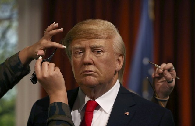 gallery assistants pose pretending to put the finishing touches to the hair and make up of a waxwork of u s president elect donald trump during a media event at madame tussauds in london britain january 18 2017 photo reuters