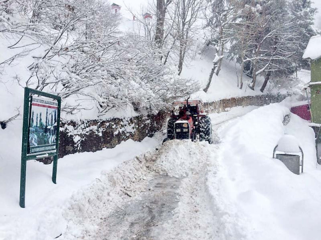 a tractor clears snow from a road in galiyat photo express a tractor clears snow from a road in galiyat photo express