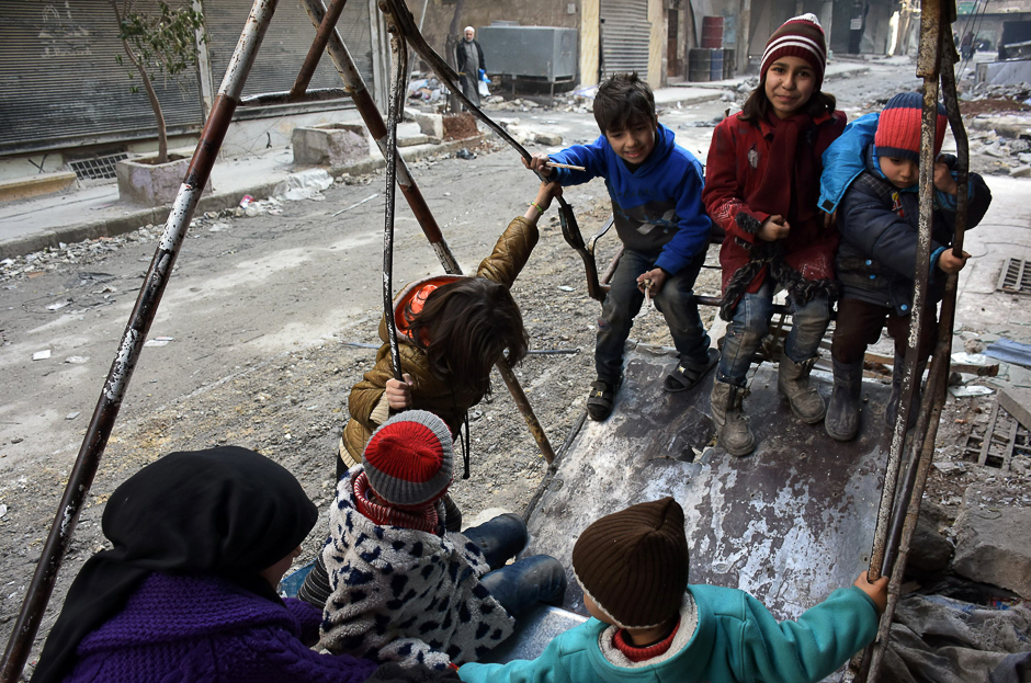 Syrian children play in a damaged street in Aleppo's Tareeq al-Bab neighbourhood. PHOTO: AFP