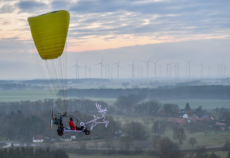 A man, disguised as Santa Claus, flies in a microlight near Sieversdorf, eastern Germany. PHOTO: AFP