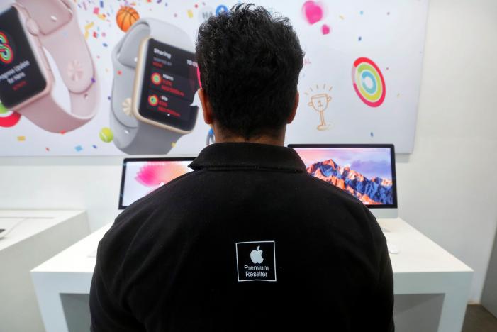 a salesperson waits for customers at an apple reseller store in mumbai india photo reuters