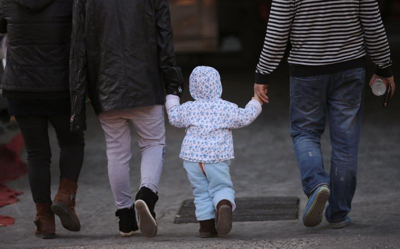 a girl holds the hands of her parents as they walk on a street in beijing november 18 2013 photo reuters