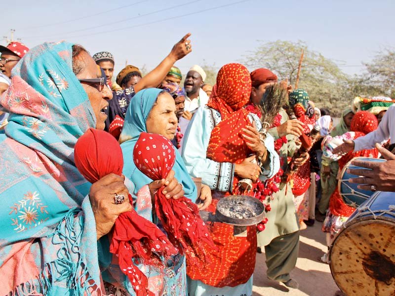 the traditional dance during the sheedi mela was led by women who wore red baskets on their heads and covered their faces with chunri dupattas photo ayesha mir express