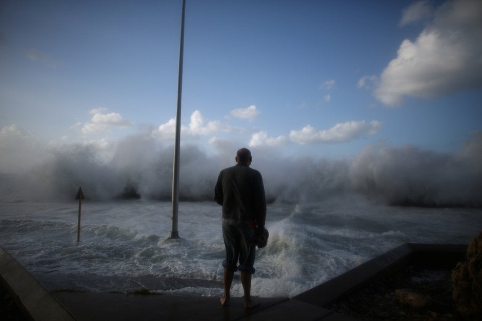 a man watches waves breaking on the malecon seafront in havana cuba photo reuters