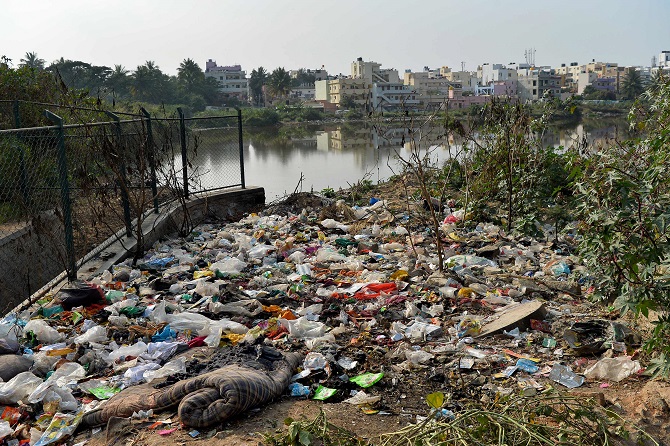 this photo taken on january 10 2017 shows garbage dumped by a lake in bangalore photo afp