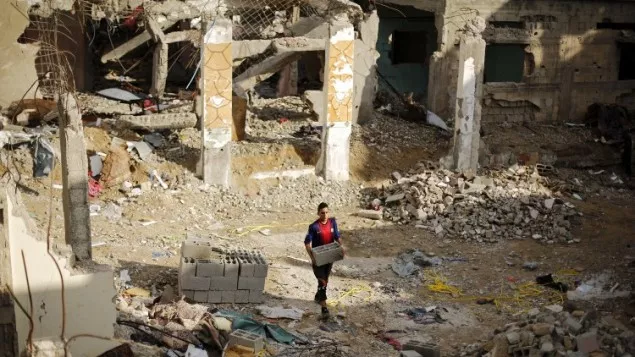 a palestinian young man carries bricks amid the rubble of destroyed buildings in beit hanoun in the northern gaza strip photo afp a palestinian young man carries bricks amid the rubble of destroyed buildings in beit hanoun in the northern gaza strip photo afp