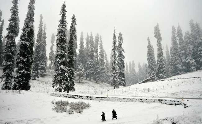 kashmiri walkers cross a snow covered area at gulmarg some 55 km north of srinagar photo afp